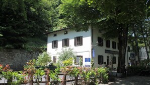 A white building with multiple windows and a sign indicating a restaurant. - Locanda dei Baroni (Poppi)