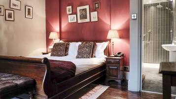 A bedroom with a wooden bed, two bedside lamps, a nightstand, and a bench.