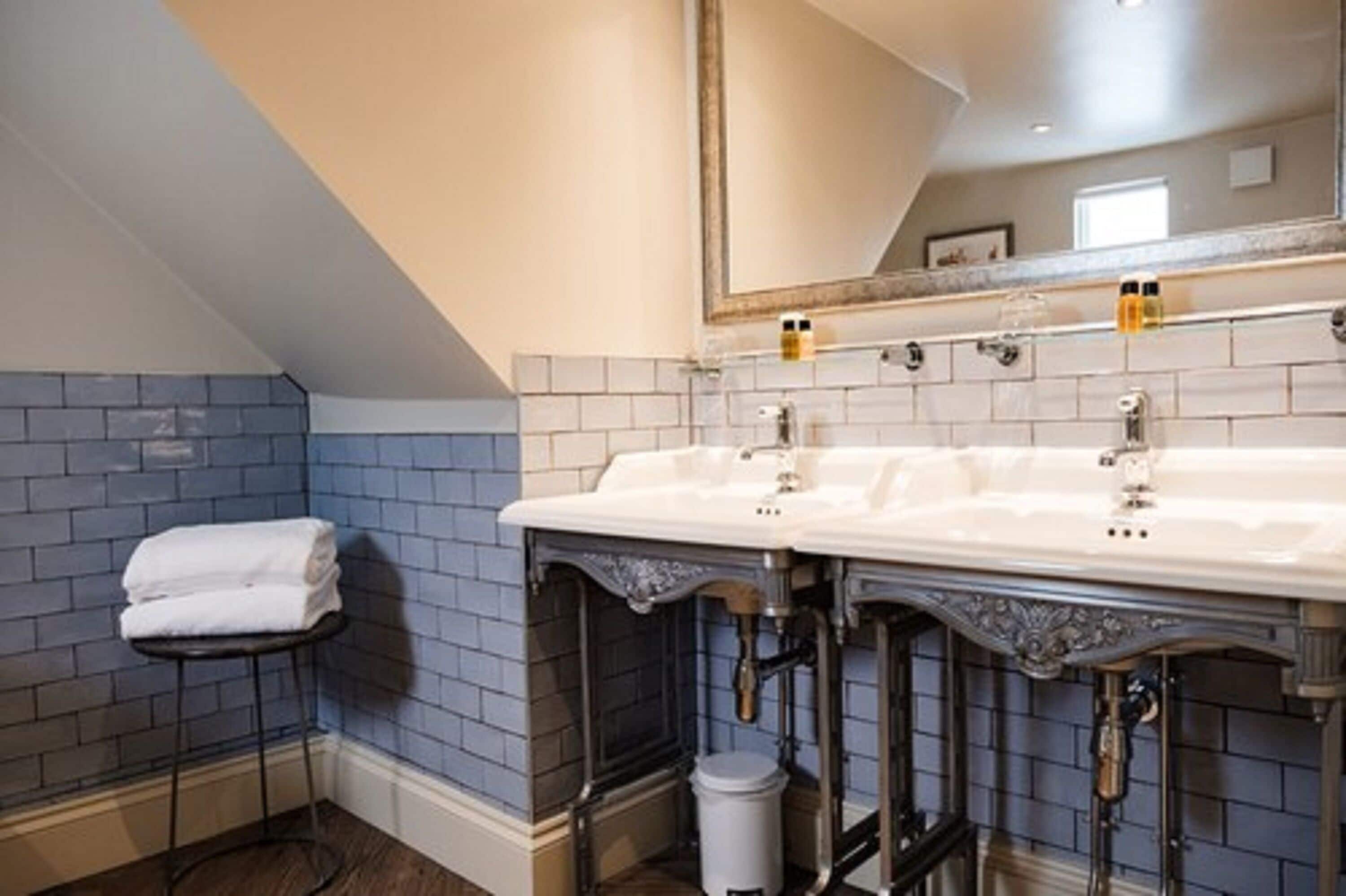 Une salle de bain avec un lavabo blanc, un miroir et un porte-serviettes.
