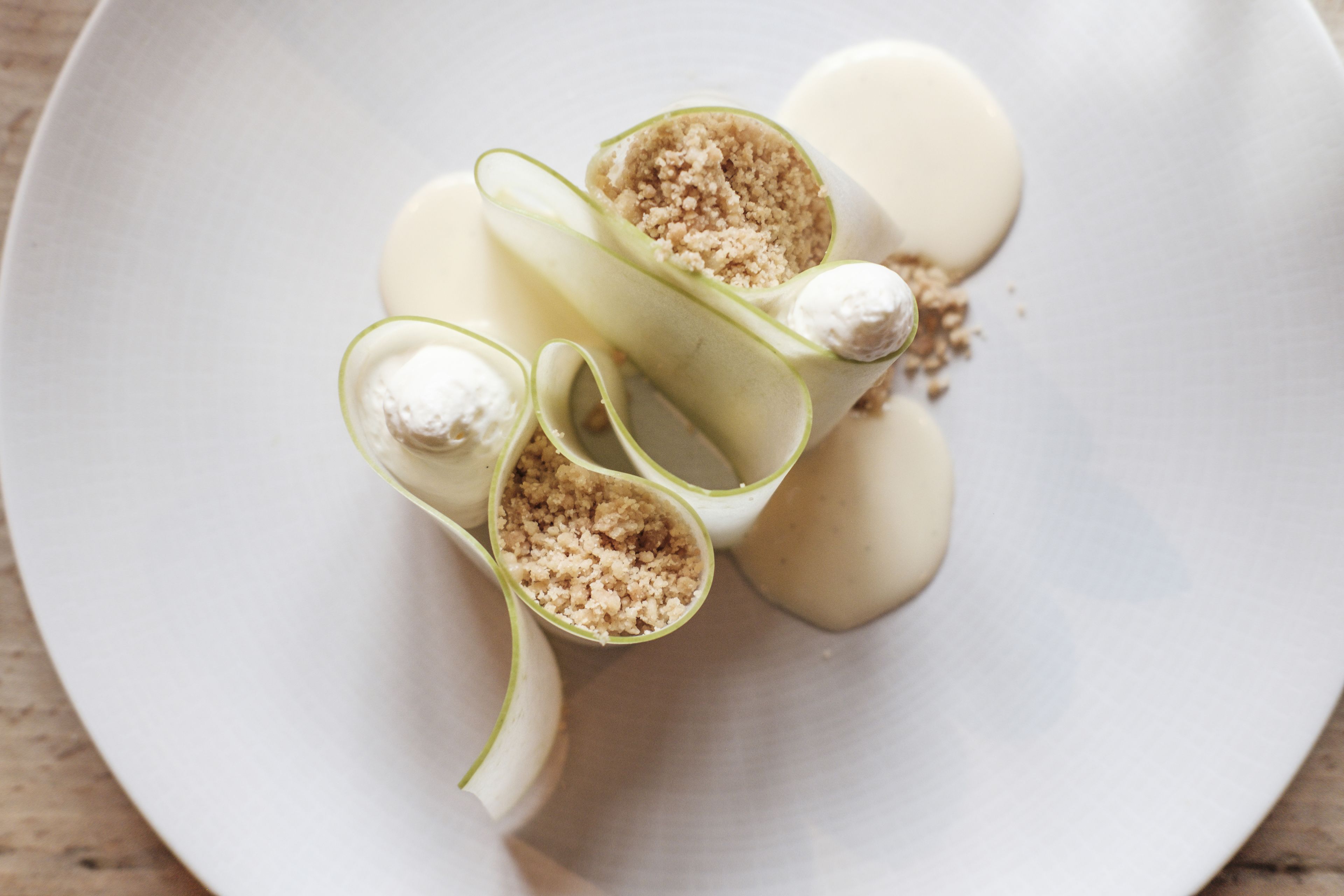 A white plate with sliced apples and a creamy filling.