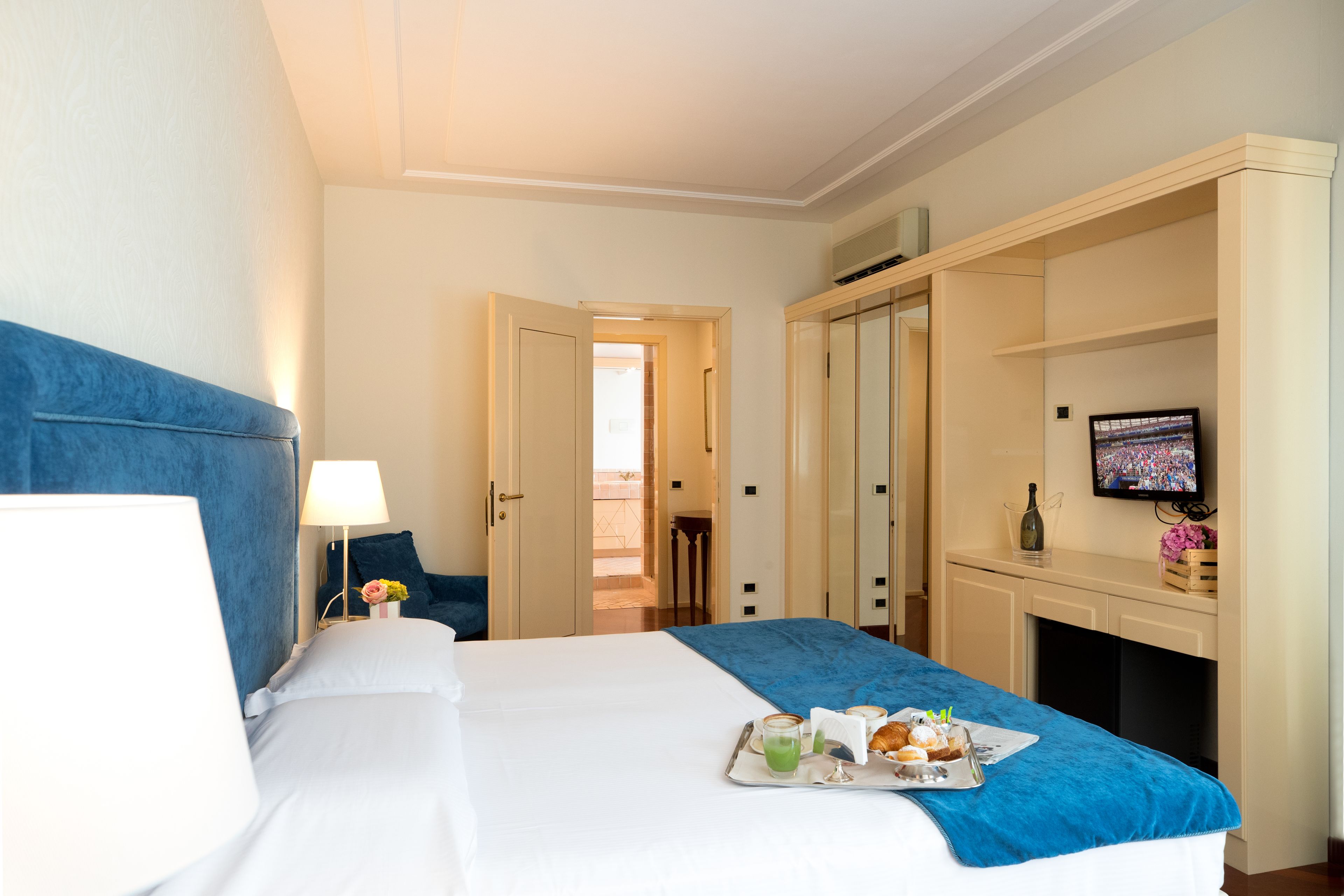 Une chambre d’hôtel comprenant un lit, un bureau avec une télévision, un minibar et une vue sur l’extérieur.