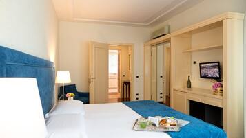 Une chambre d’hôtel comprenant un lit, un bureau avec une télévision, un minibar et une vue sur l’extérieur.