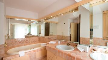 Un baño moderno con una bañera grande, un lavabo y un espejo.
