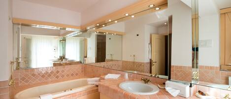 Un baño moderno con una bañera grande, un lavabo y un espejo.