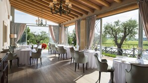 A dining area with tables and chairs, large windows, and a view of the outdoors. - Villa Cordevigo  (Cavaion Veronese)