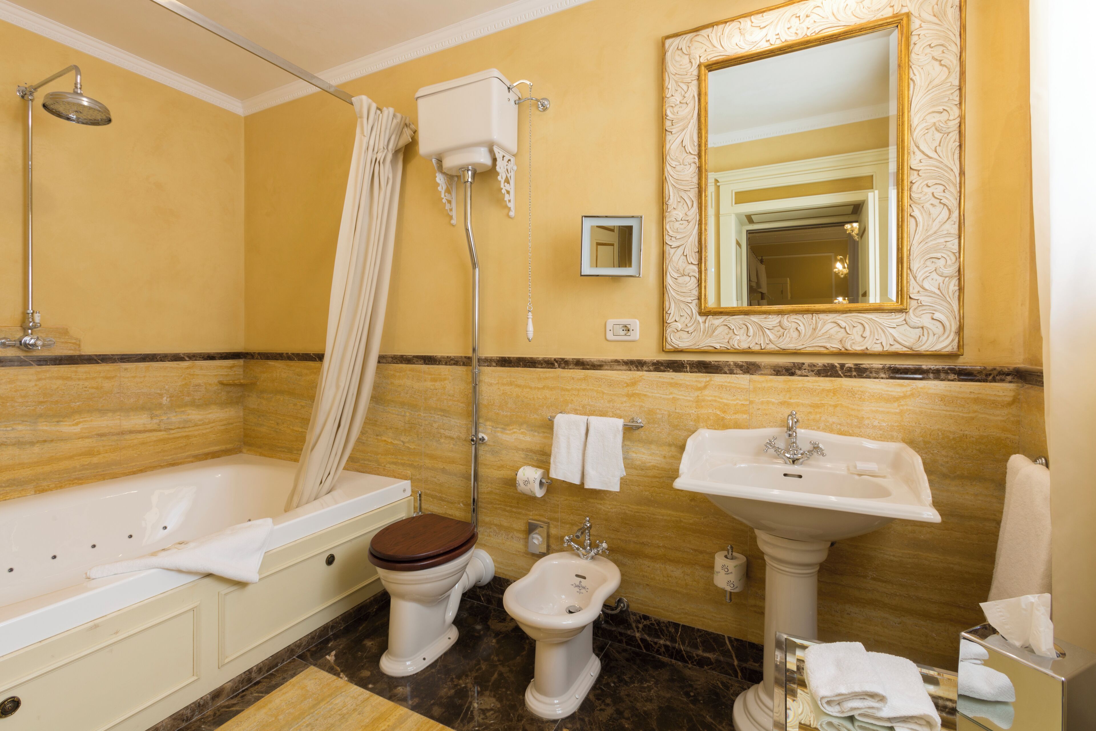 Un bagno con vasca, wc, bidet e lavandino.