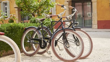 Una bicicleta estacionada sobre grava, con un edificio al fondo.