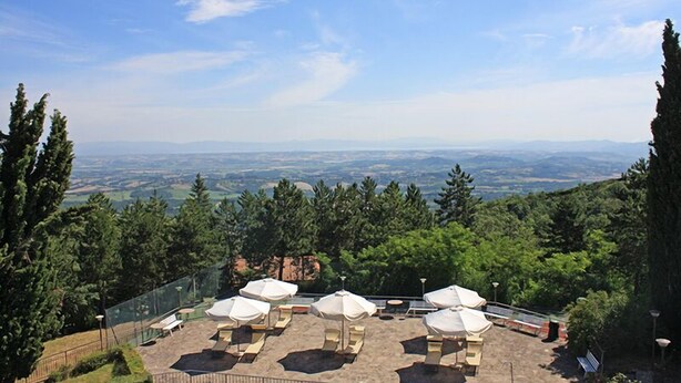 Una terraza en la azotea con mobiliario exterior y vistas panorámicas del campo.