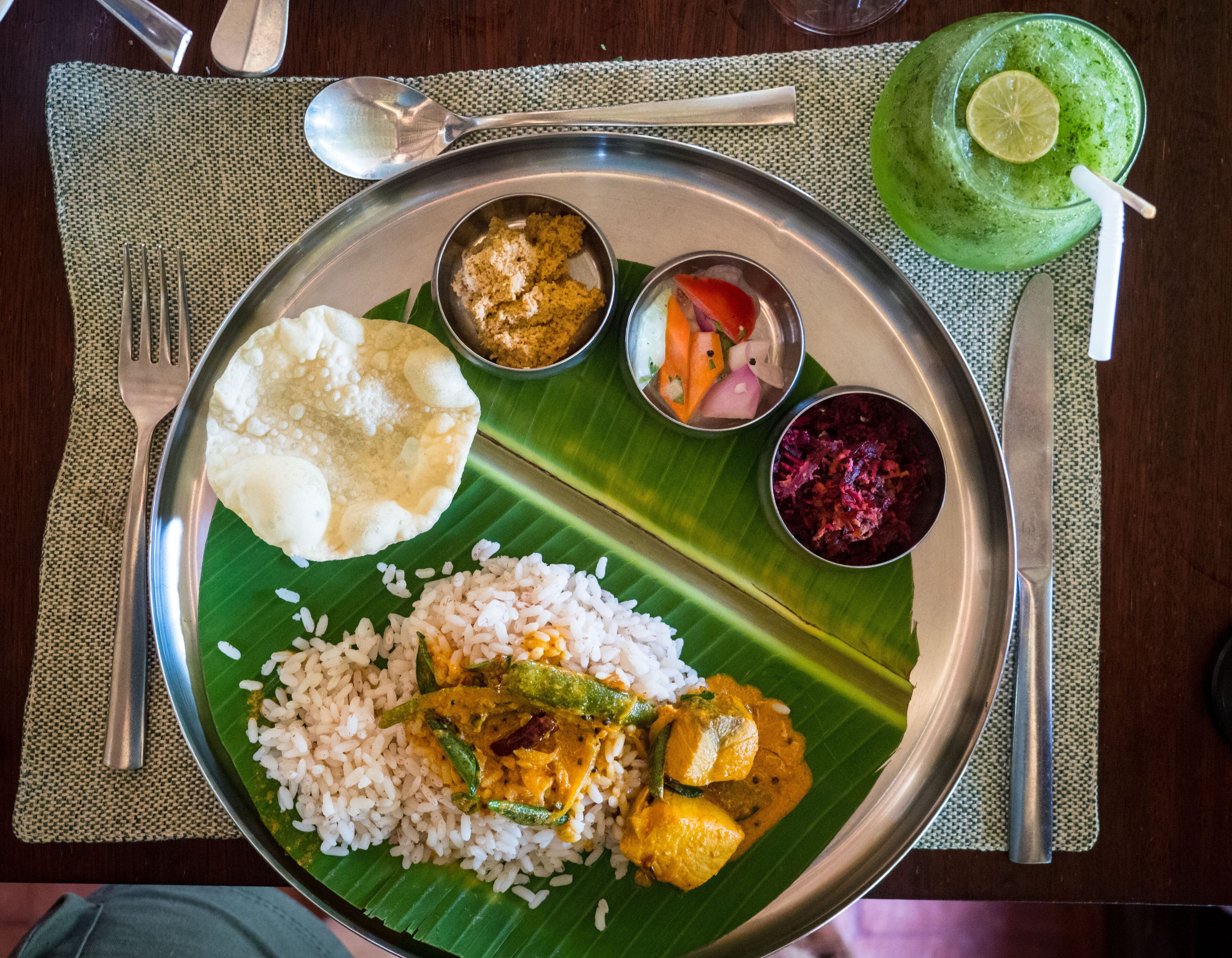 A plate with rice, curry, and a banana leaf.
