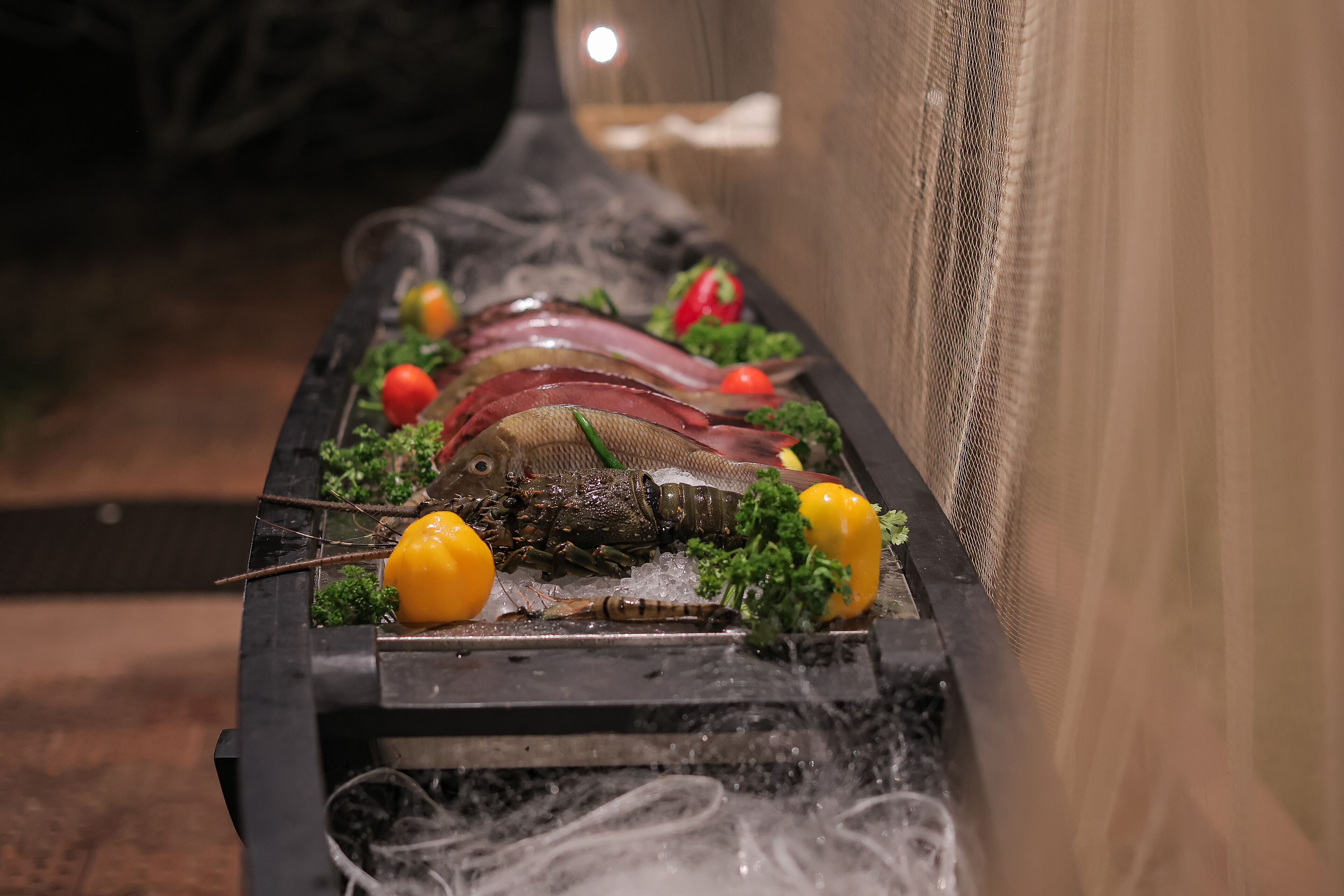 A seafood platter with various types of fish and vegetables.