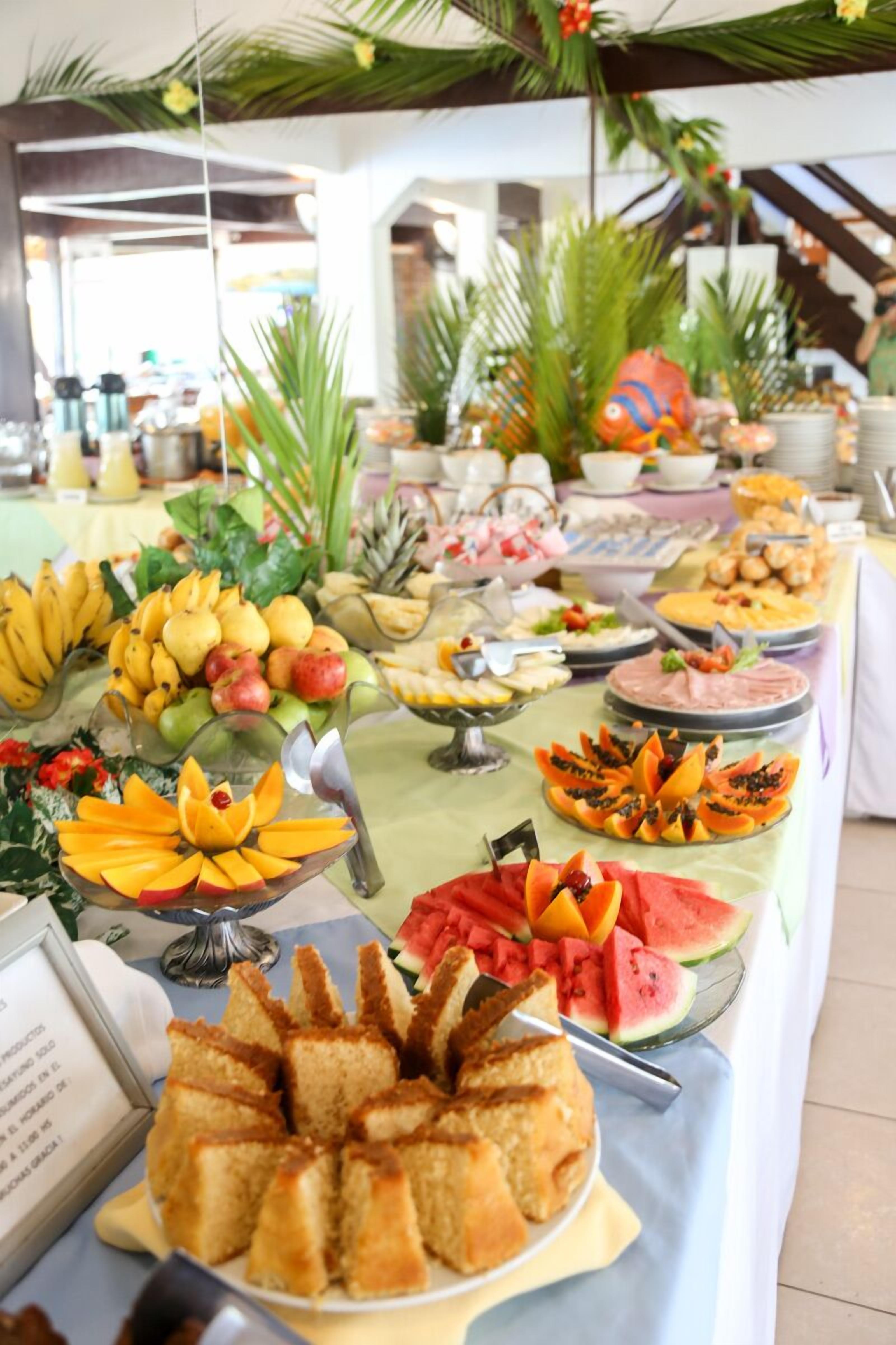 A buffet table with various fruits, vegetables, and desserts.