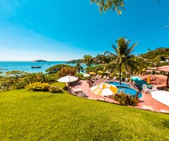 Una piscina al aire libre, sombrillas, sillones reclinables de piscina