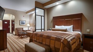 A hotel room with a large bed, a desk, a chair, and a television. - Best Western Plus KC Speedway Inn & Suites (Kansas City)