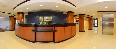 A reception area with a curved counter, a glass display, and an elevator.