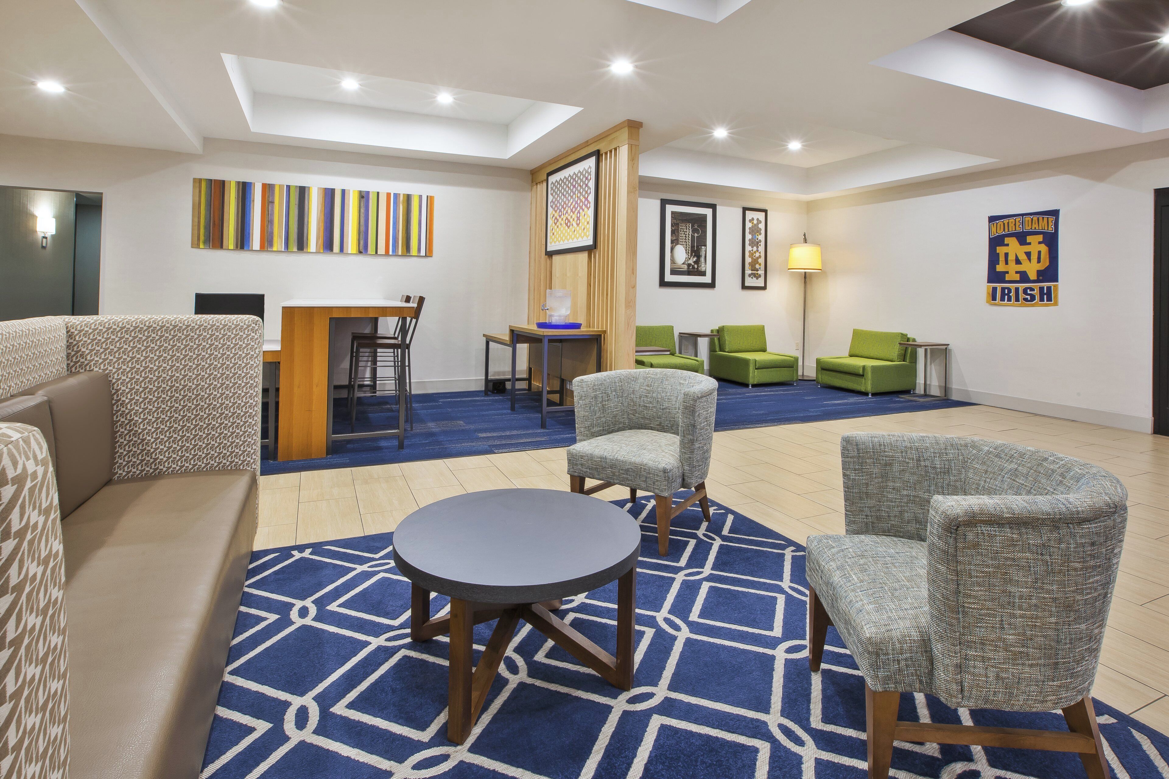 Eine Hotelhalle mit Sitzgelegenheit, einer Rezeption und einem großen Fenster.