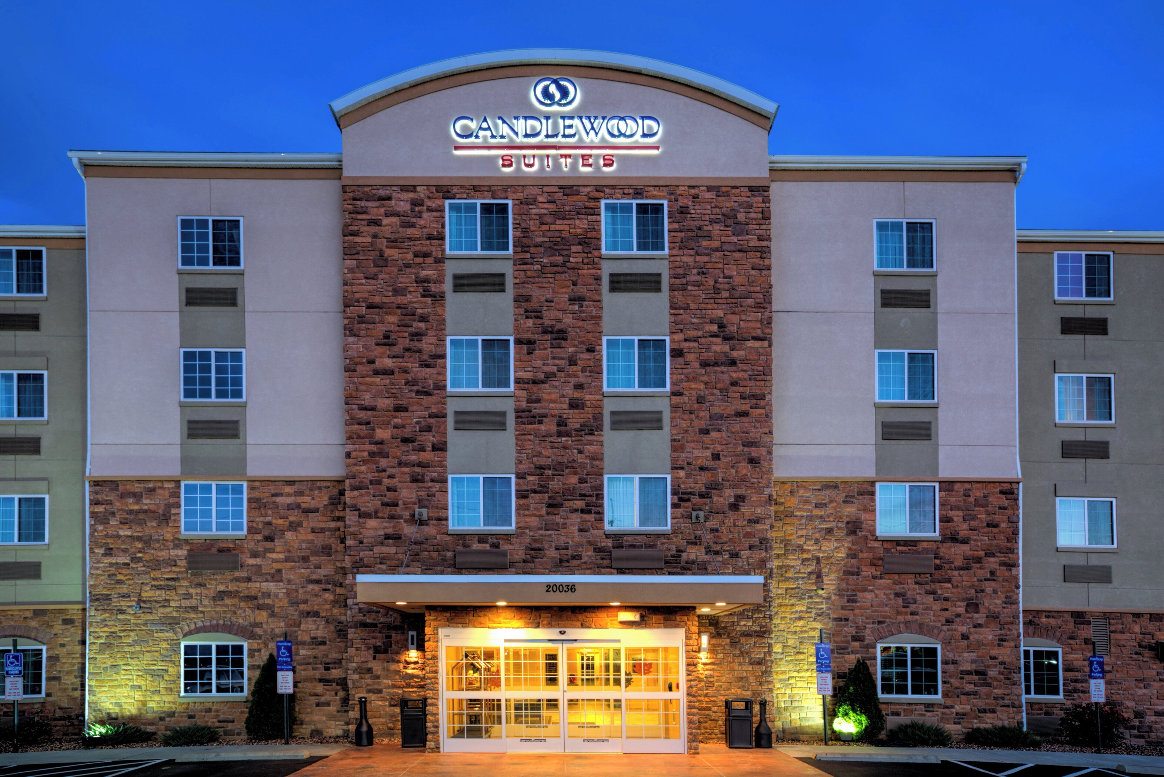 A hotel with a brick facade, multiple windows, and a sign indicating it is a Candlewood Suites.
