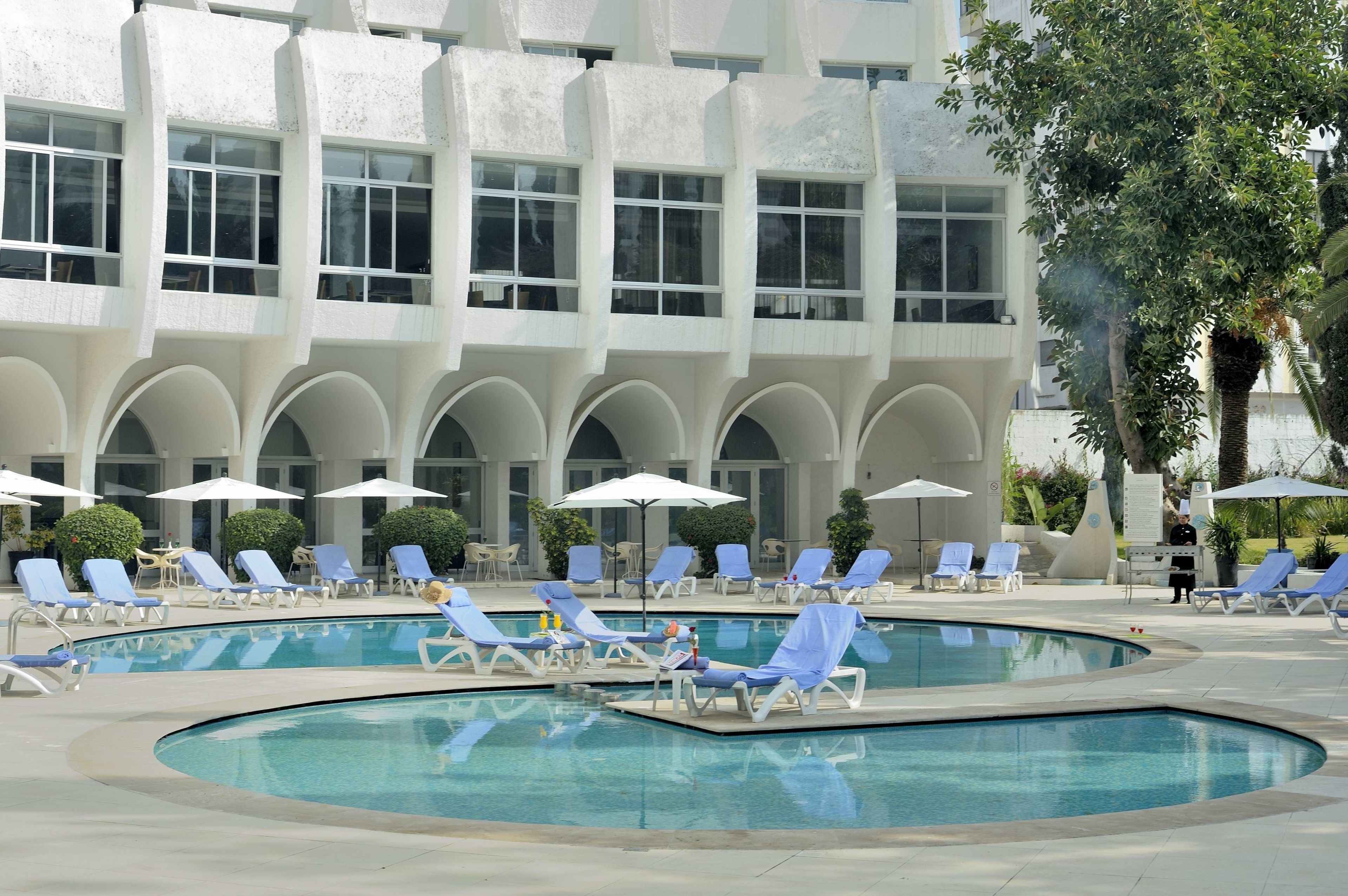 Una piscina al aire libre de temporada, sombrillas