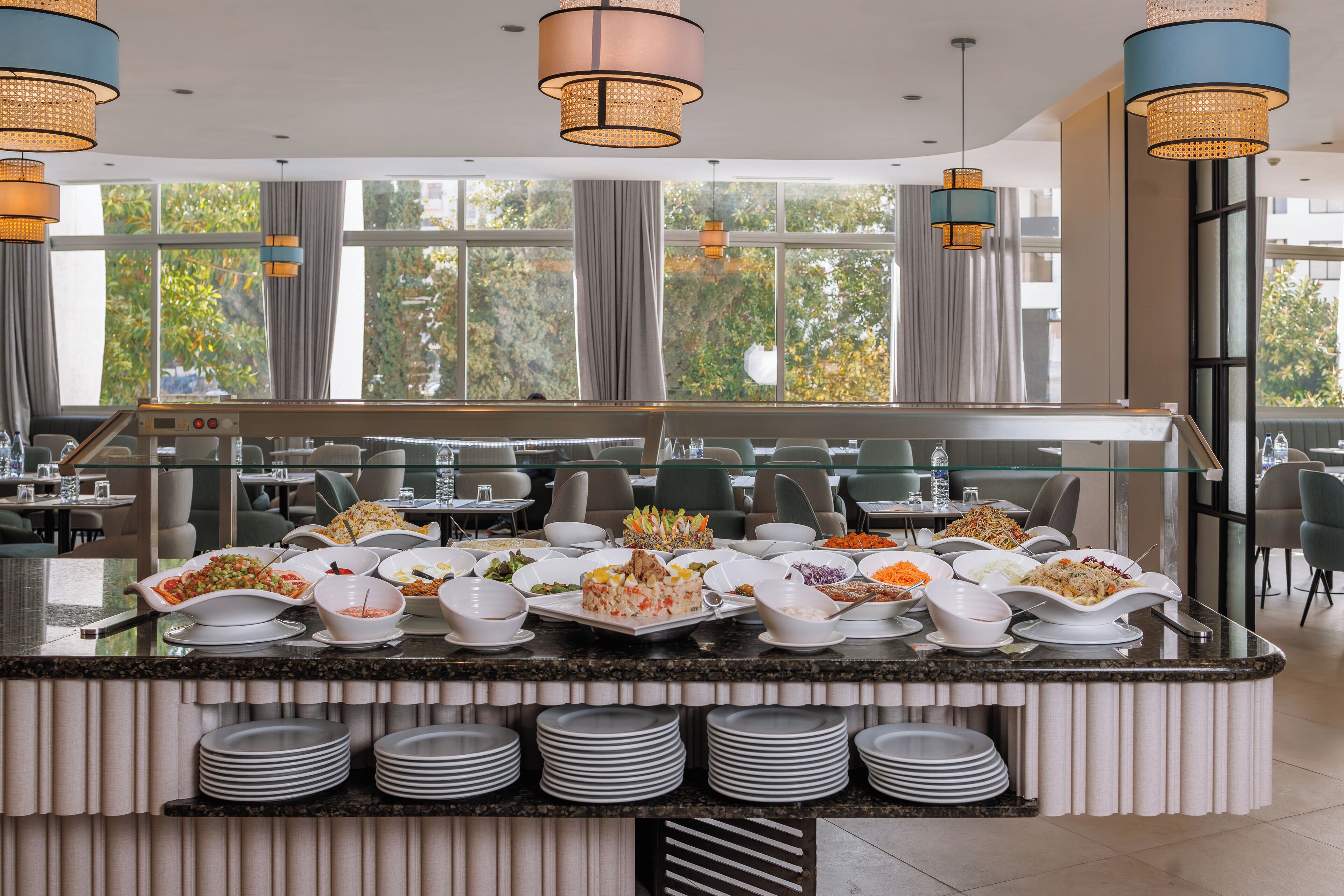 A buffet setup with various dishes and a seating area in the background.