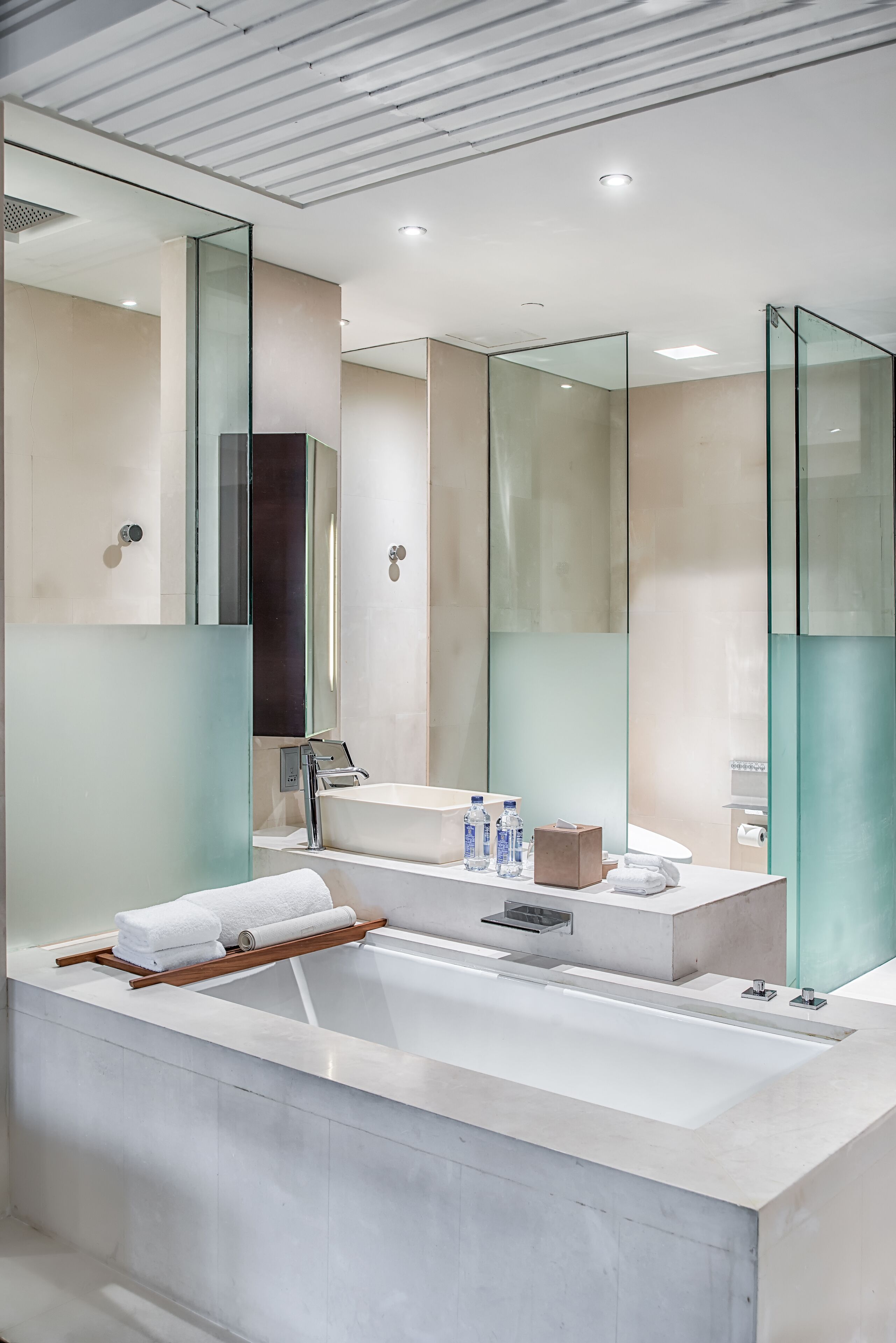 A modern bathroom with a large bathtub, a glass shower enclosure, and a vanity with a mirror.