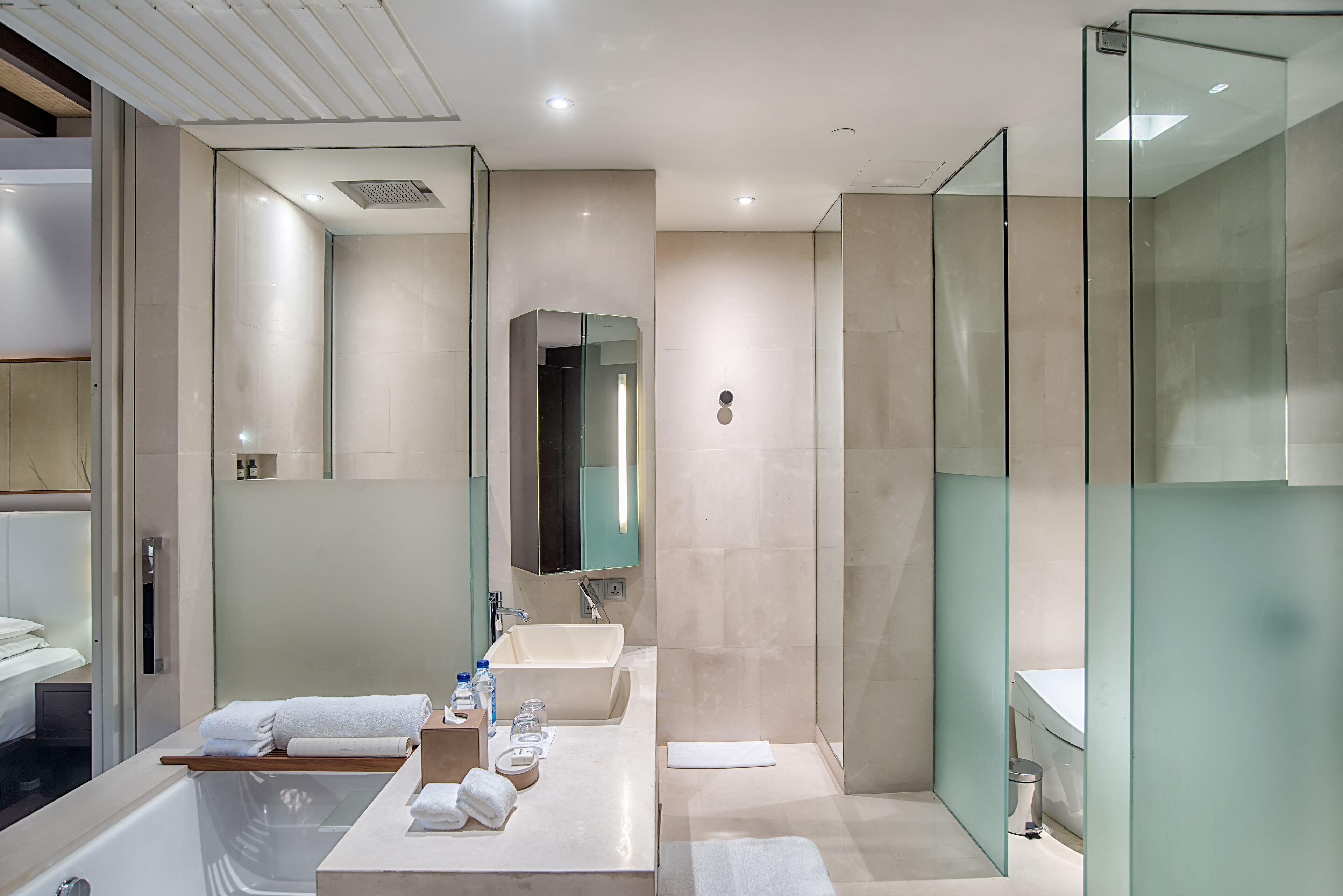 A modern bathroom with a glass shower enclosure, a double sink vanity, and a bathtub.