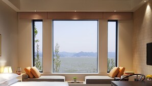 Una habitación de hotel moderna con una cama grande, un escritorio y vista al agua.