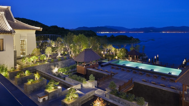 Un resort con piscina, zonas de estar al aire libre y vista al mar.
