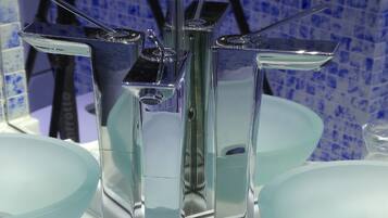 A bathroom with three glass sinks and a mirror.