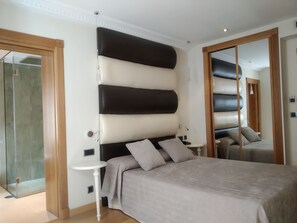 Sengetøy av topp kvalitet, dundyner, minibar og safe på rommet