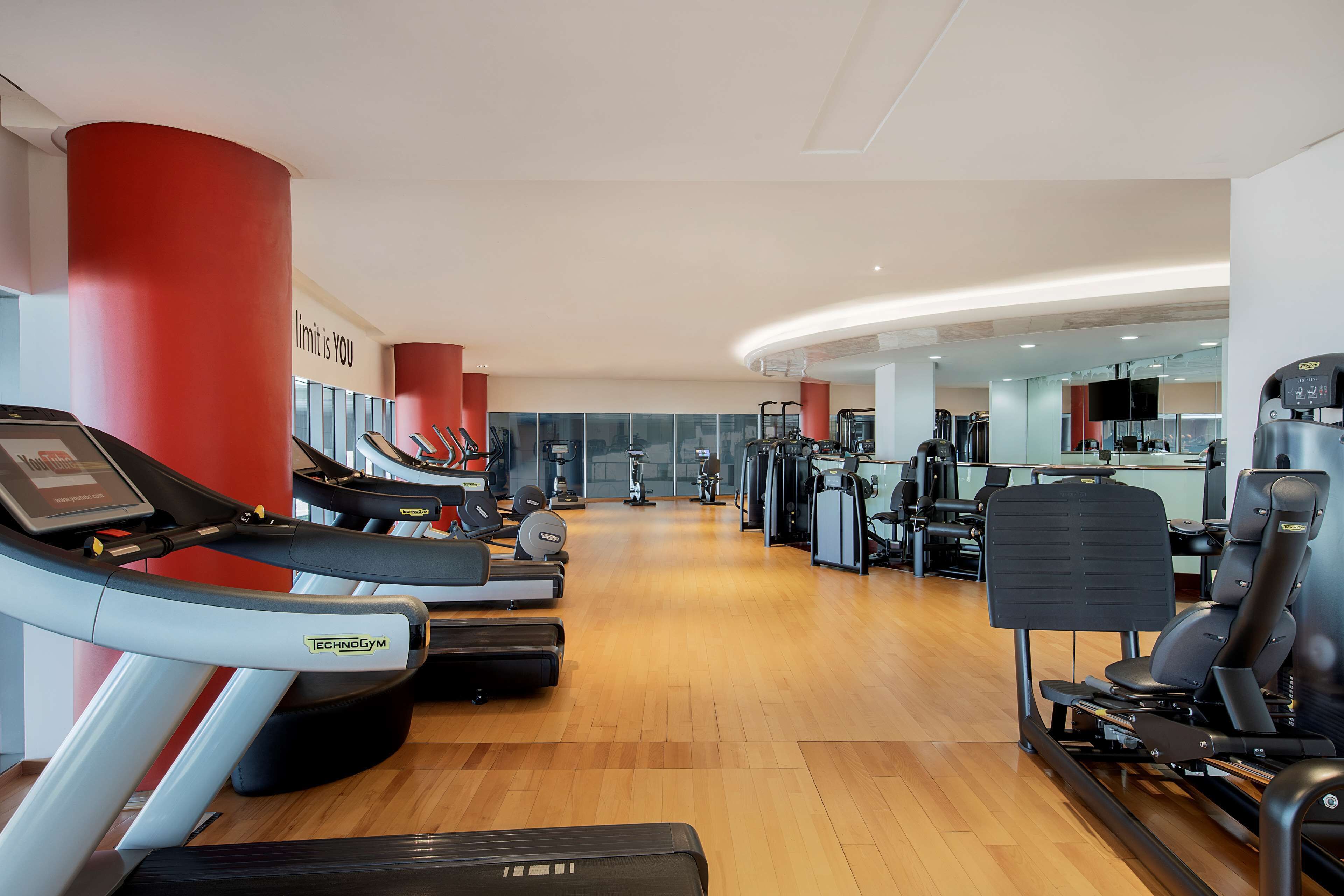 Een fitnessruimte met loopbanden, krachtapparaten en trainingsapparatuur.