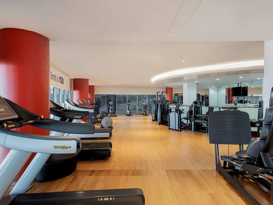 A gym with treadmills, weight machines, and exercise equipment.