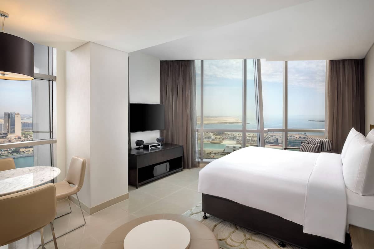Una habitación de hotel moderna con una cama grande, un escritorio y vistas a la ciudad.