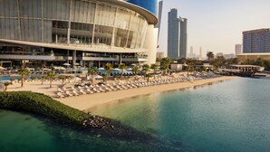 A waterfront hotel with a pool, beach area, and modern architecture. - Conrad Abu Dhabi Etihad Towers (Abu Dhabi)