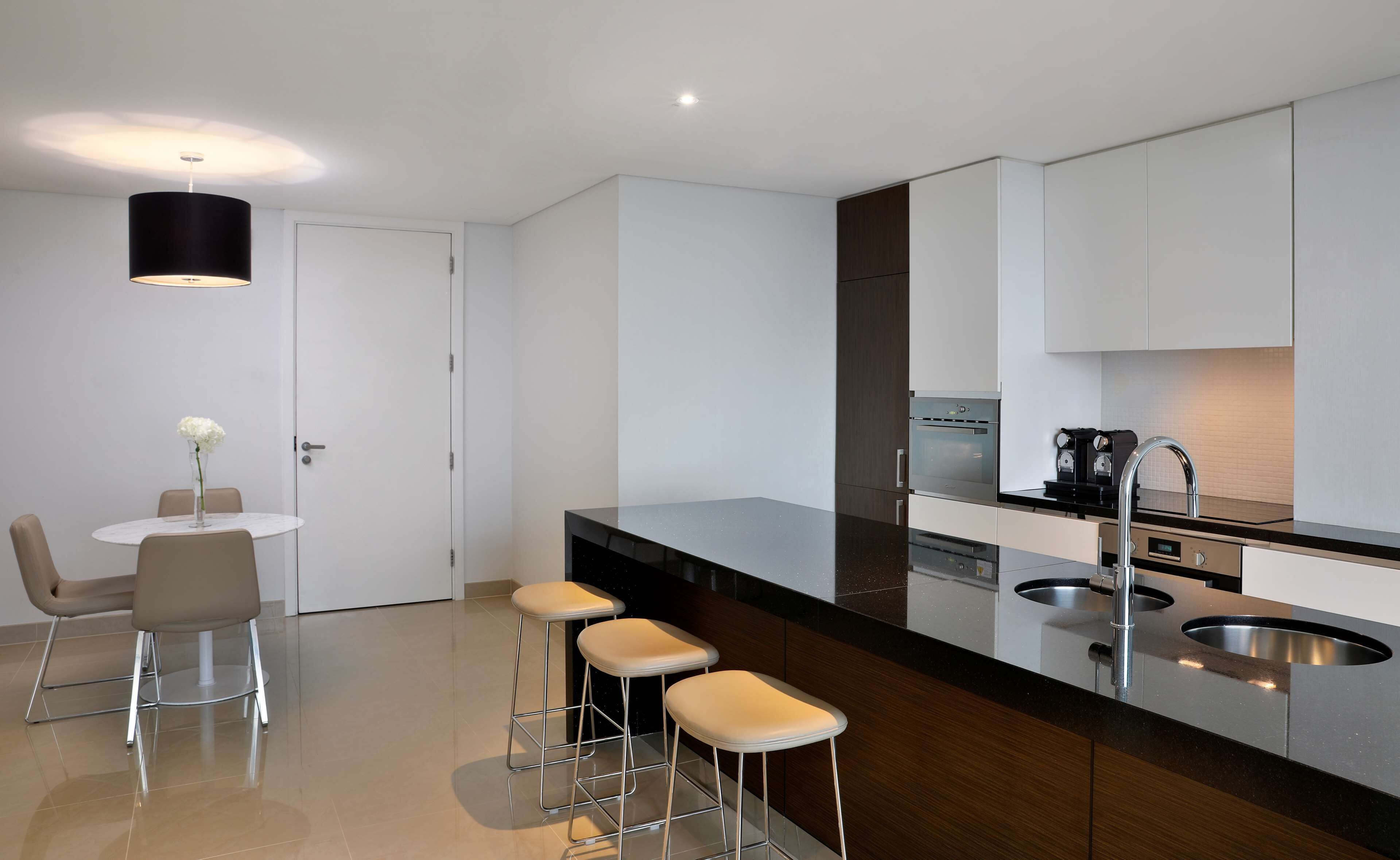 A modern kitchen with a central island, stainless steel appliances, and a minimalist design.