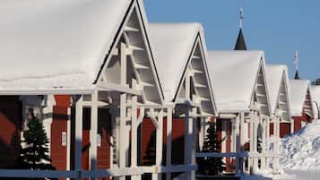 Una hilera de edificios cubiertos de nieve con un diseño de techo triangular característico, probablemente parte de un hotel o complejo turístico.