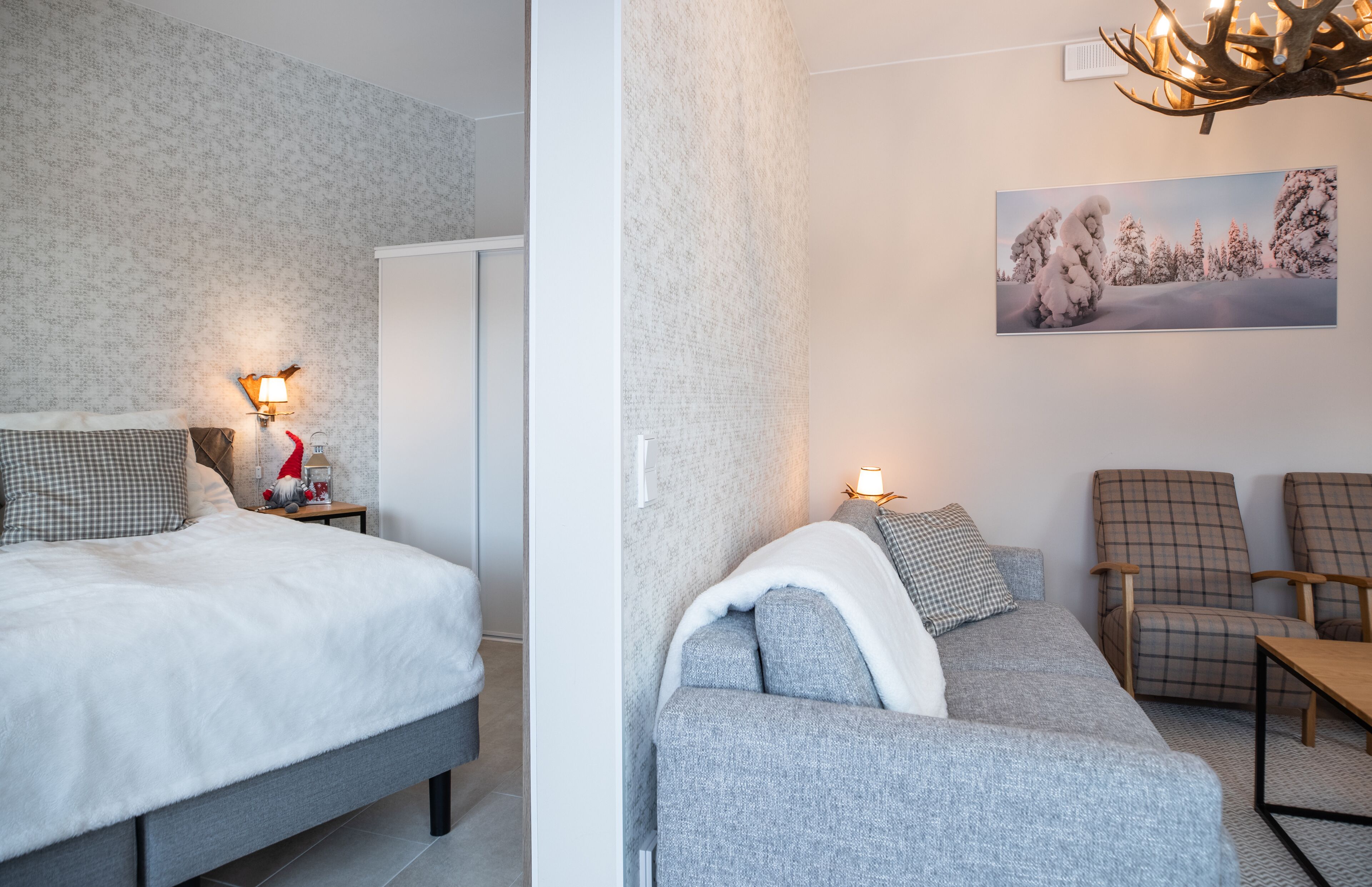 A bedroom with a bed, bedside table, lamp, and a wardrobe.