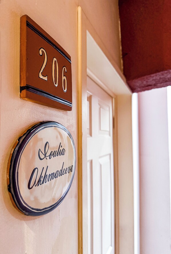 A door with a number plate reading "206" and a round plate with the name "Soulia Othmanova".