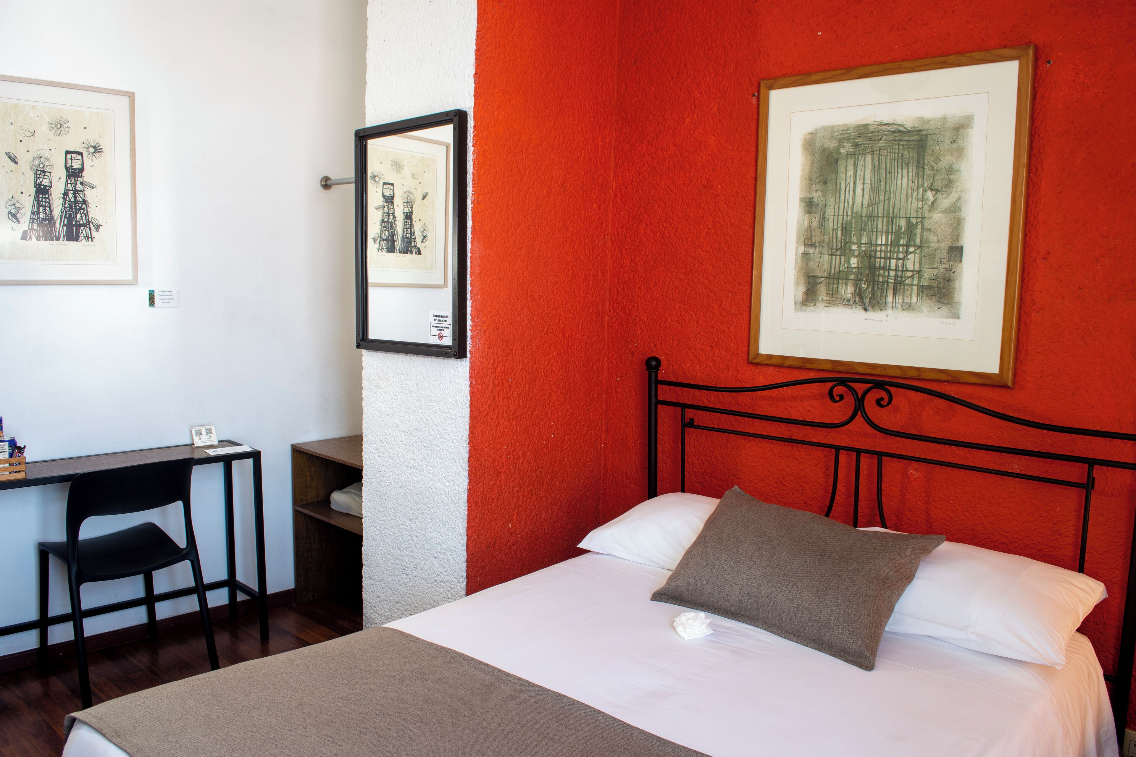 Une chambre d’hôtel avec un lit, un bureau et une chaise.