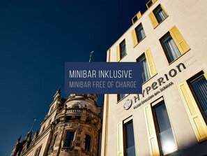 A hotel facade with classical architecture, including ornate balconies and a prominent corner tower.