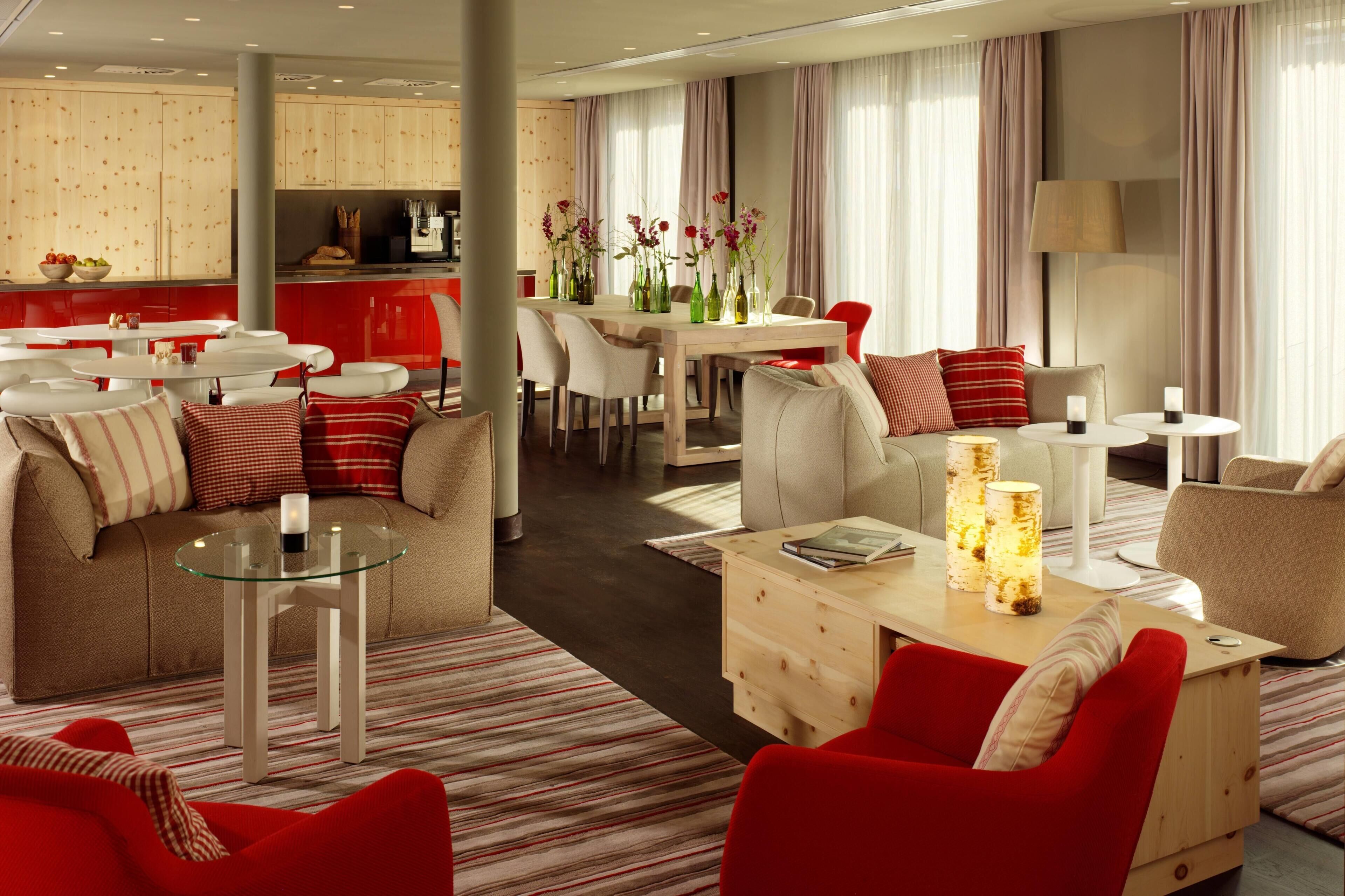 A modern hotel room with a dining area, a sofa set, and a coffee table.