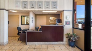 Un mostrador de recepción con un cartel de Econoloog by Choice Hotels, una computadora, un teléfono y una planta en maceta.