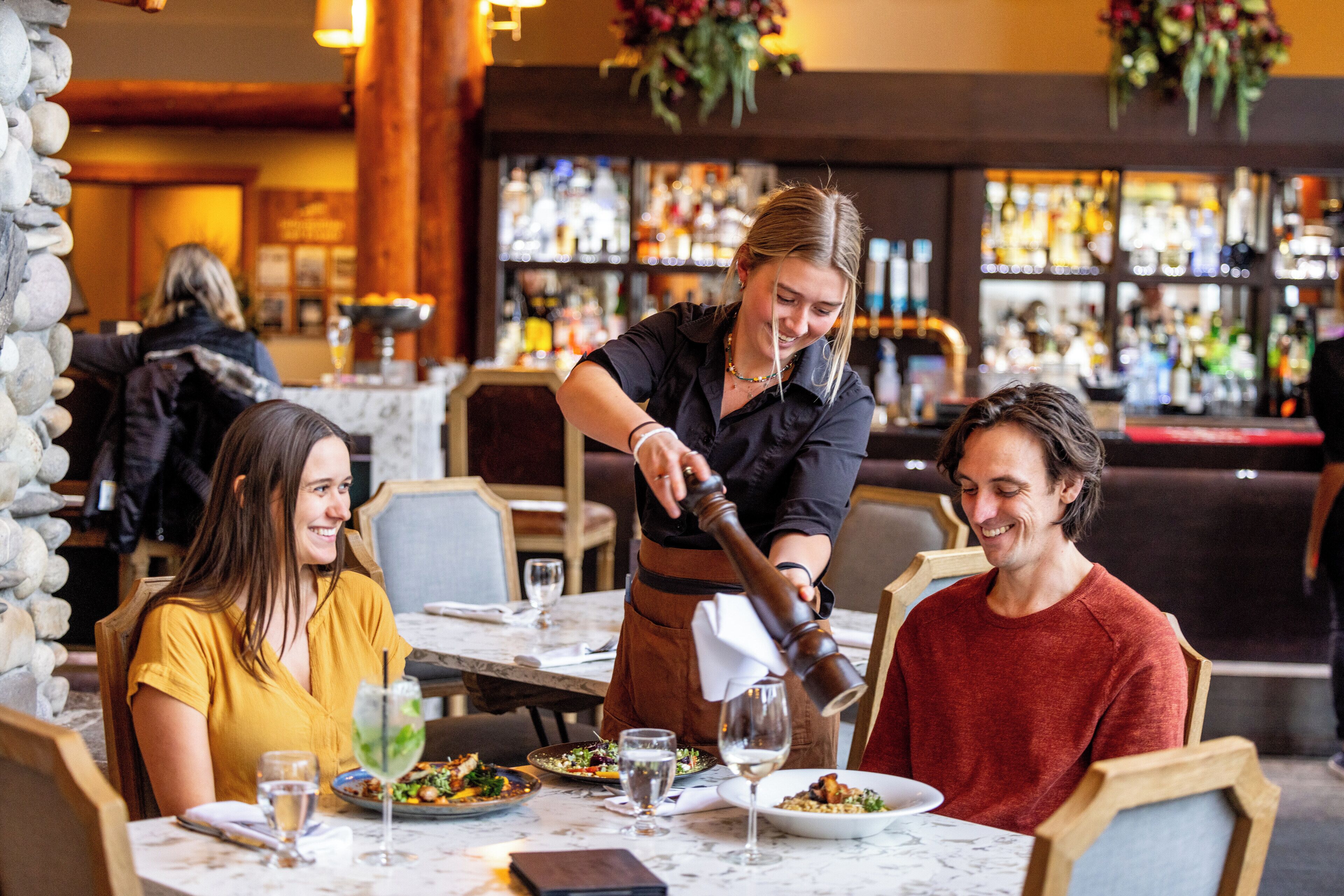 Ein Restaurantinneres mit Tischen, Stühlen und einer Theke im Hintergrund.