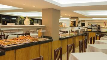 A buffet area with a variety of food items, a coffee machine, and seating arrangements.