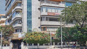 A multi-story hotel with balconies, a central glass elevator shaft, and a sign for the Bentley Hotel. - Bentley Hotel Marine Drive (Mumbai)