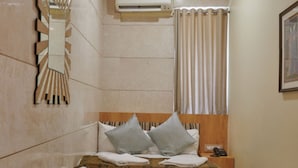 A bedroom with a bed, bedside table, and an air conditioning unit. - Bentley Hotel Marine Drive (Mumbai)