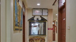 A hallway with a polished floor, a decorative console table, and a sign indicating available rooms. - Bentley Hotel Marine Drive (Mumbai)