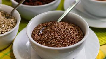 A table with various food items in bowls, including beans, seeds, and a chocolate spread.