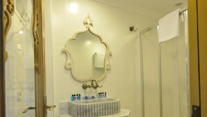 Une salle de bain avec un meuble-lavabo, un miroir et une douche.