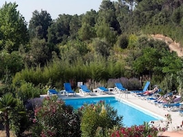 Una piscina al aire libre de temporada, tumbonas