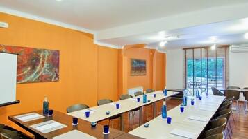A conference room with a long table, chairs, and a whiteboard.