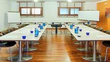 A conference room with a long table, chairs, and a whiteboard.